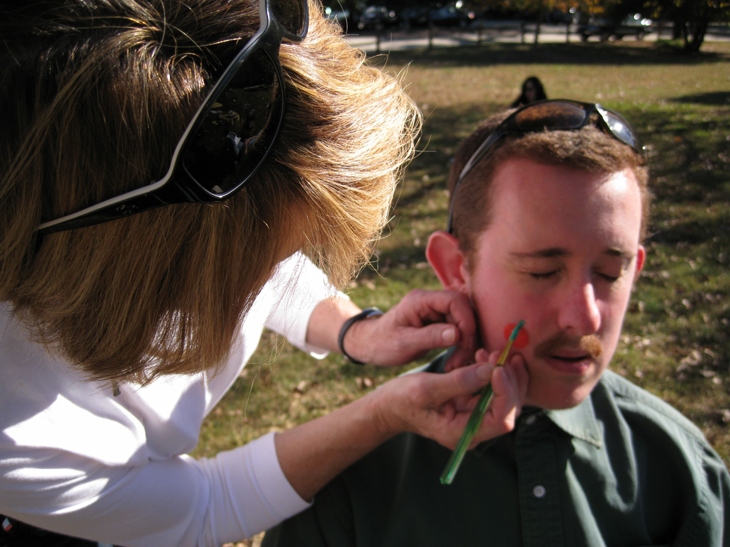 Man getting face painted at picnic
