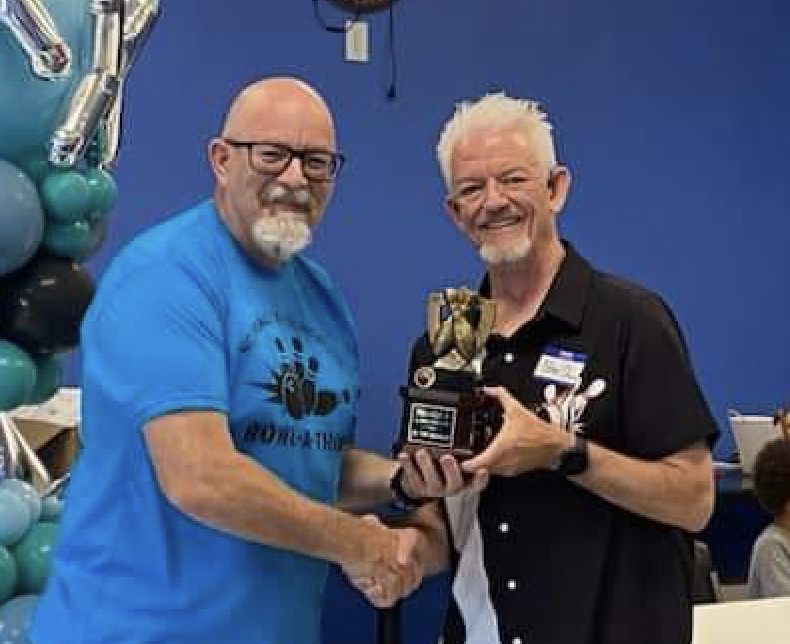 Gideon Adams, winner of the coveted bowling trophy for 2023, accepting the award from NCFXF Board President Steve Strom