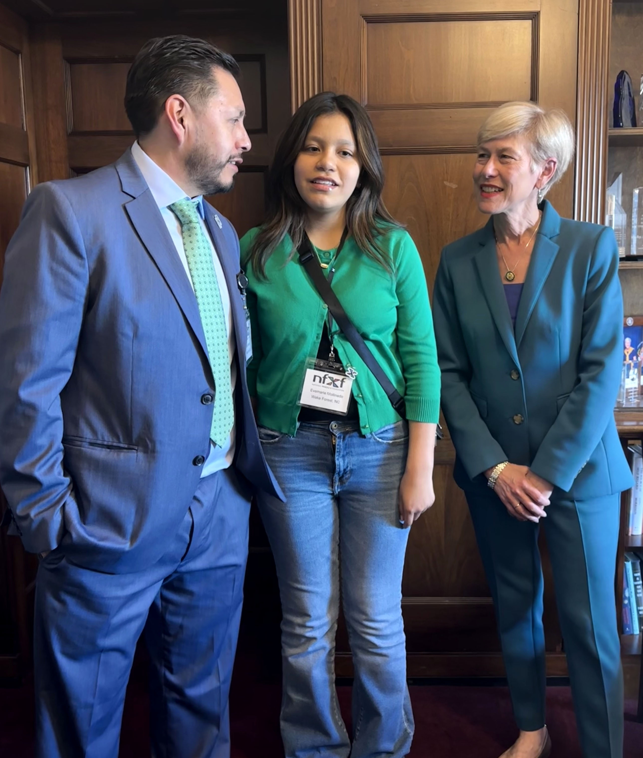 Representative Deborah Ross (C) with advocates Juan Mollinedo and his daughter Evemarie.