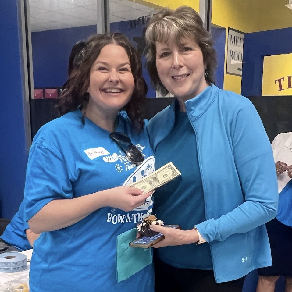 NCFXF President Brittney Miller awards the 50/50 raffle winnings to Rosalie McCuddy.