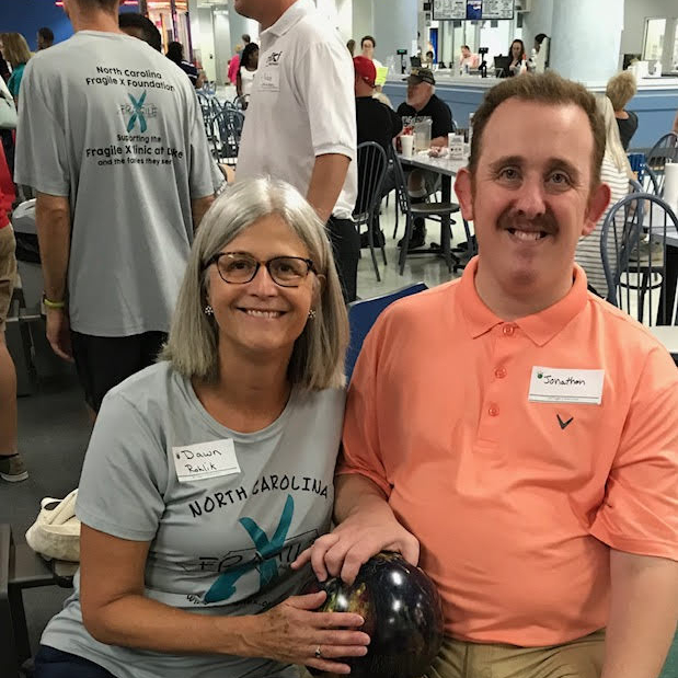 Dawn Rohlik holding a bowling ball with a gentleman at the NC Fragile X Bowl-A-Thon.