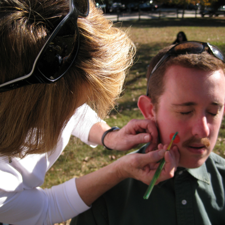 Man getting face painted at picnic