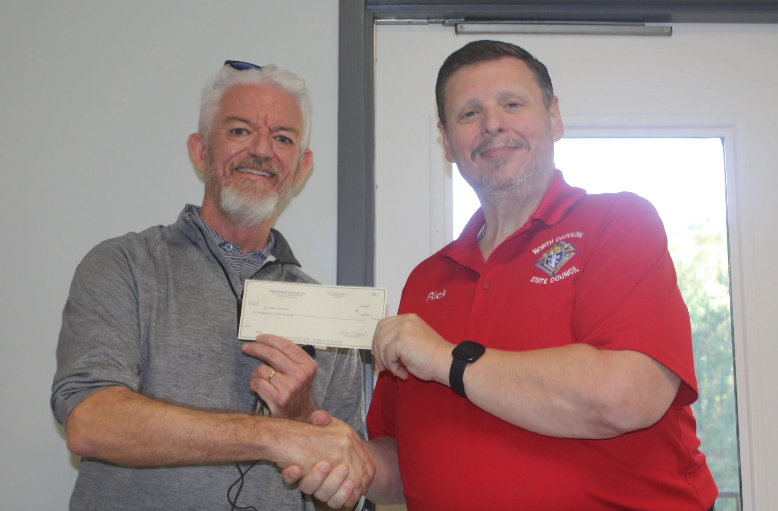 President Steve Strom (L) accepted a generous donation from  the Knights of Columbus and their state treasurer, Rick Lewis (R). 