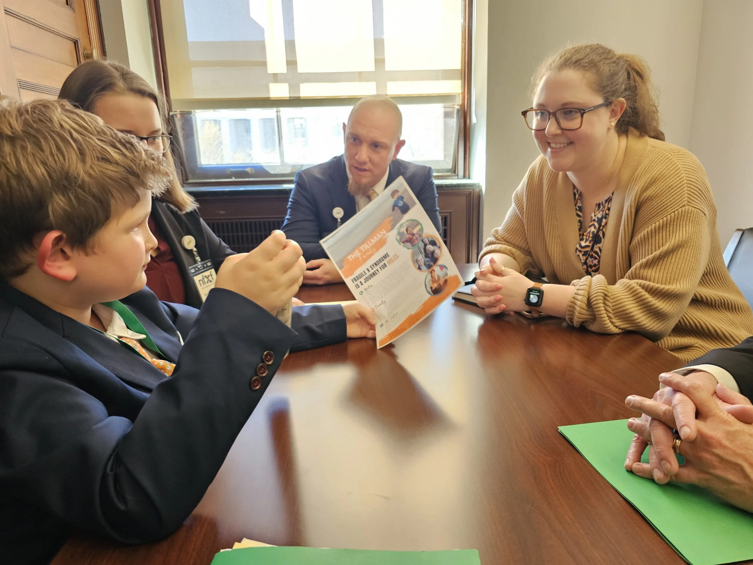 Eight-year-old Miles Tillman telling his story to the legislative aide to Representative Wiley Nickel, Rachel Kline. (From left to right), Miles, his sister Mary Haven, dad David and Kline.